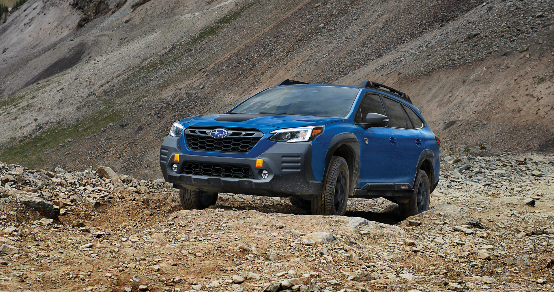 A 2023 Outback Wilderness driving on a trail in the mountains. | Five Star Subaru in Grapevine TX