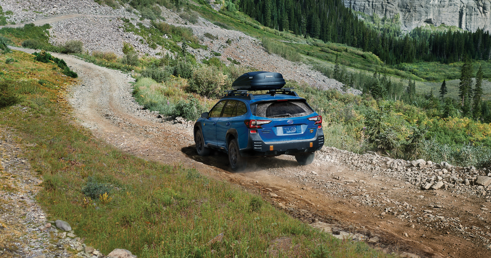A 2023 Outback Wilderness driving on a trail in the mountains. | Five Star Subaru in Grapevine TX