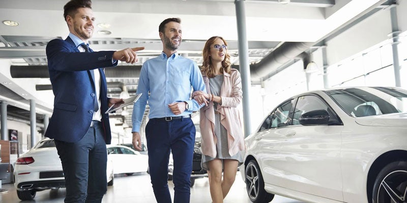 Couple shopping in dealership showroom
