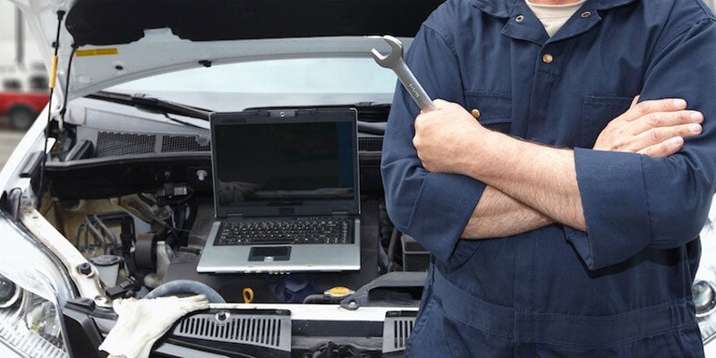 Technician with wrench and laptop